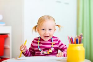 little girl holding a pencil