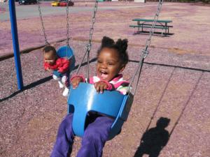 little girl happily swinging