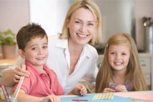 two children smiling with their teacher